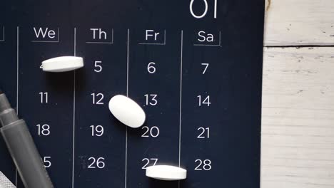 vista superior de las pastillas y el estetoscopio en el calendario