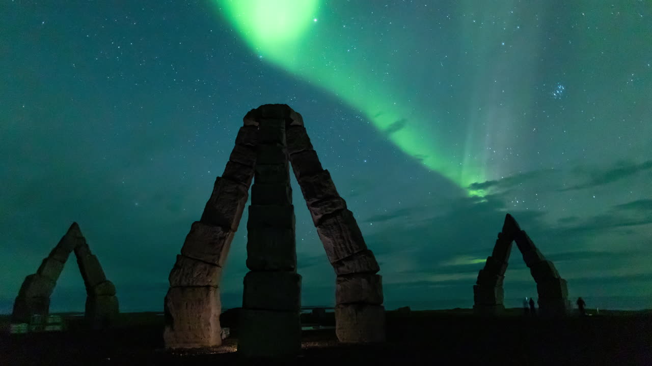Aurora borealis glowing green over the iconic landmark Arctic Henge, in north east Iceland. Time lapse