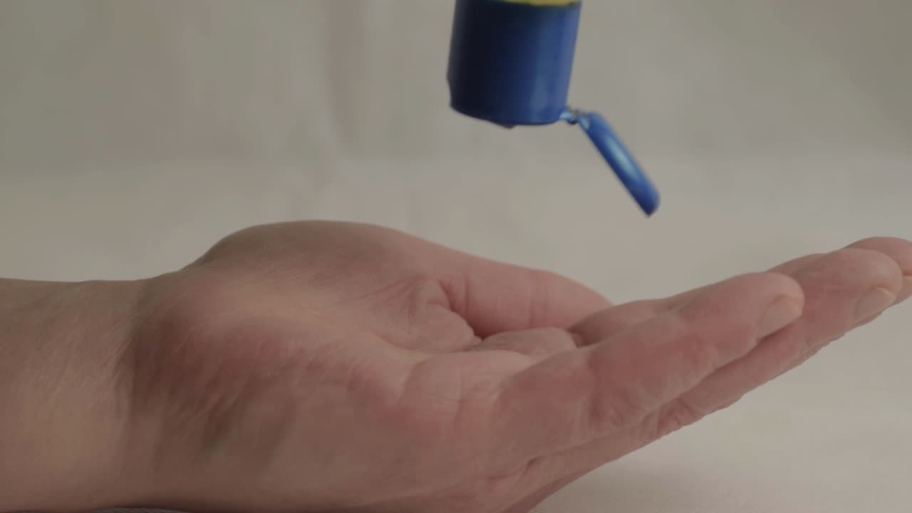 Hands using bottle of sanitizer gel close up shot