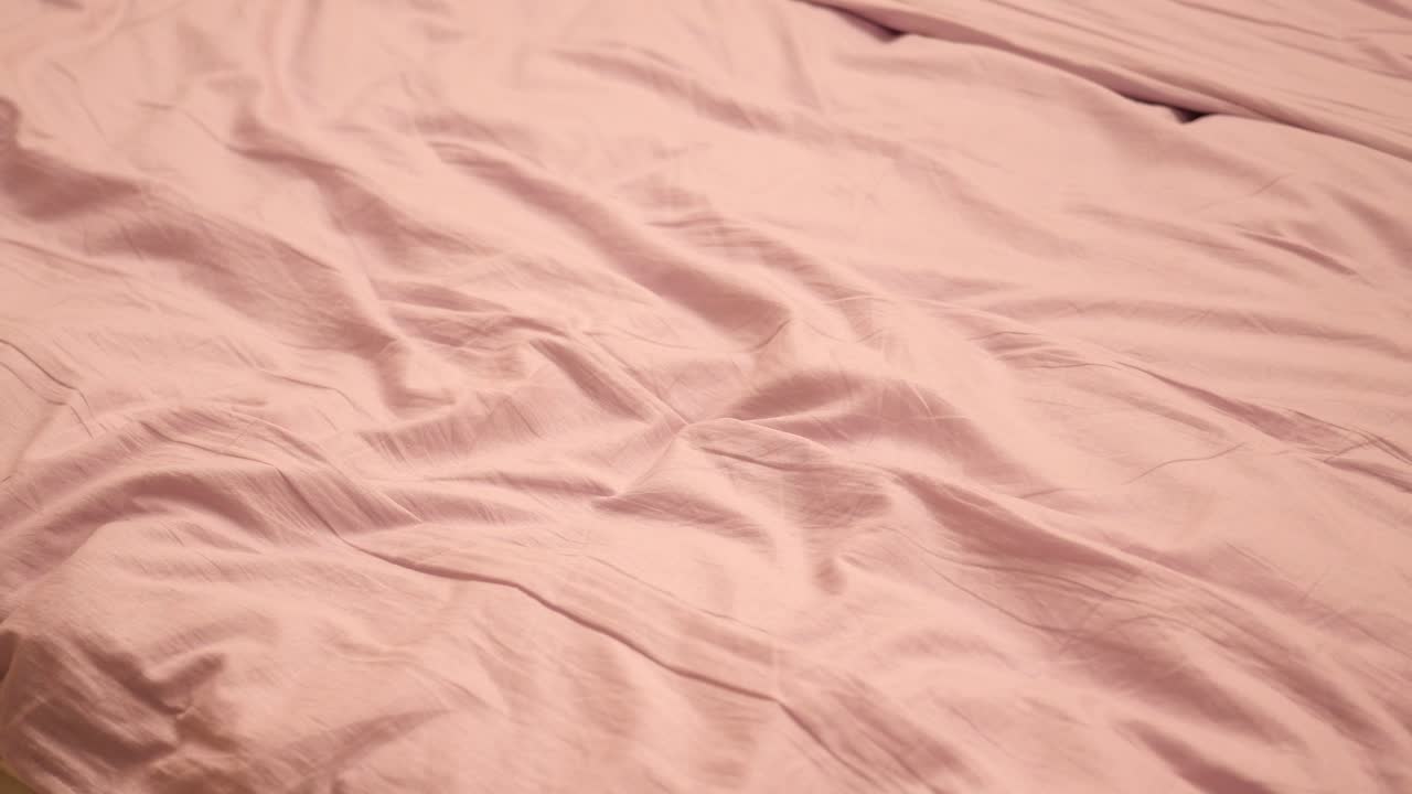 primer plano de una sábana de cama rosada