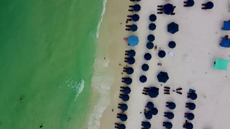 Rotating-or-turning-Aerial-view-of-beach-chairs-on-the-beachfront-resort