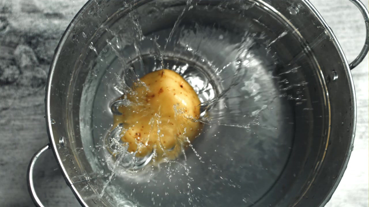 Fresh Potato Dropping into Water in Slow Motion