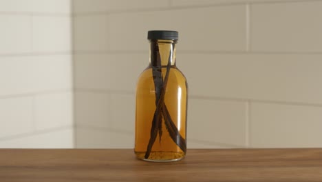 botella destilada de vainilla con granos de vainilla todavía en el líquido