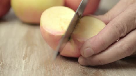 slicing a juicy red and yellow apple with a sharp knife