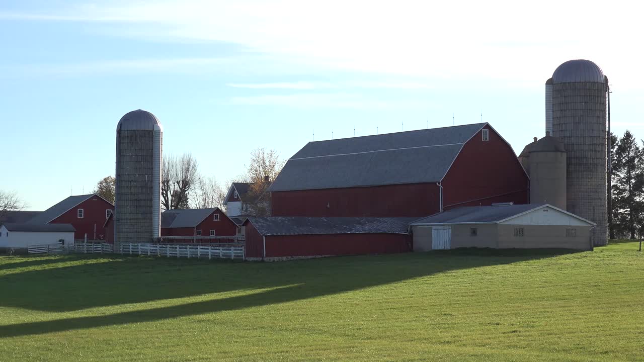 Overblik over en mejerigård i Wisconsin, mens køer går ind i stalden