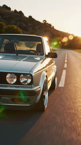 silver classic car on road at sunset