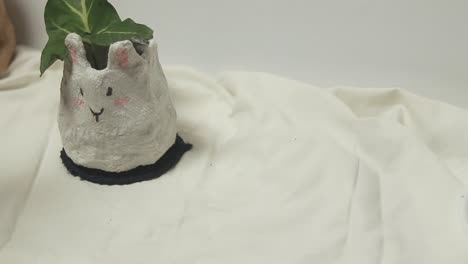 un lindo conejo de papel maché en una olla de plantas