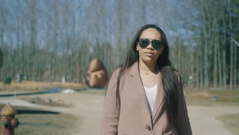 A-beautiful-woman-in-a-wool-coat-navigates-her-way-through-an-art-park-on-a-cold-winter-day