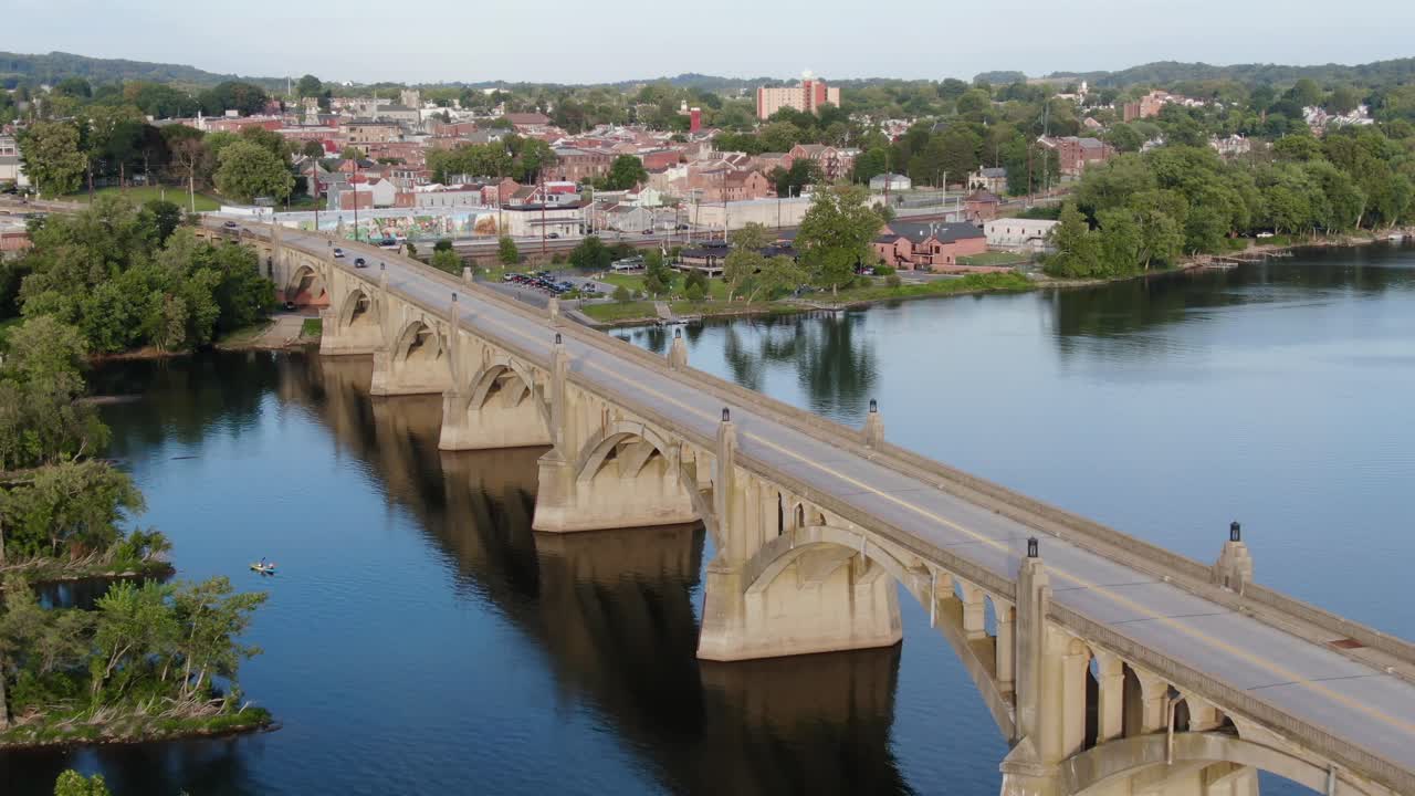 toma aérea lenta sobre el río susquehanna largo puente arqueado de hormigón con el distrito de columbia, pennsylvania en la distancia