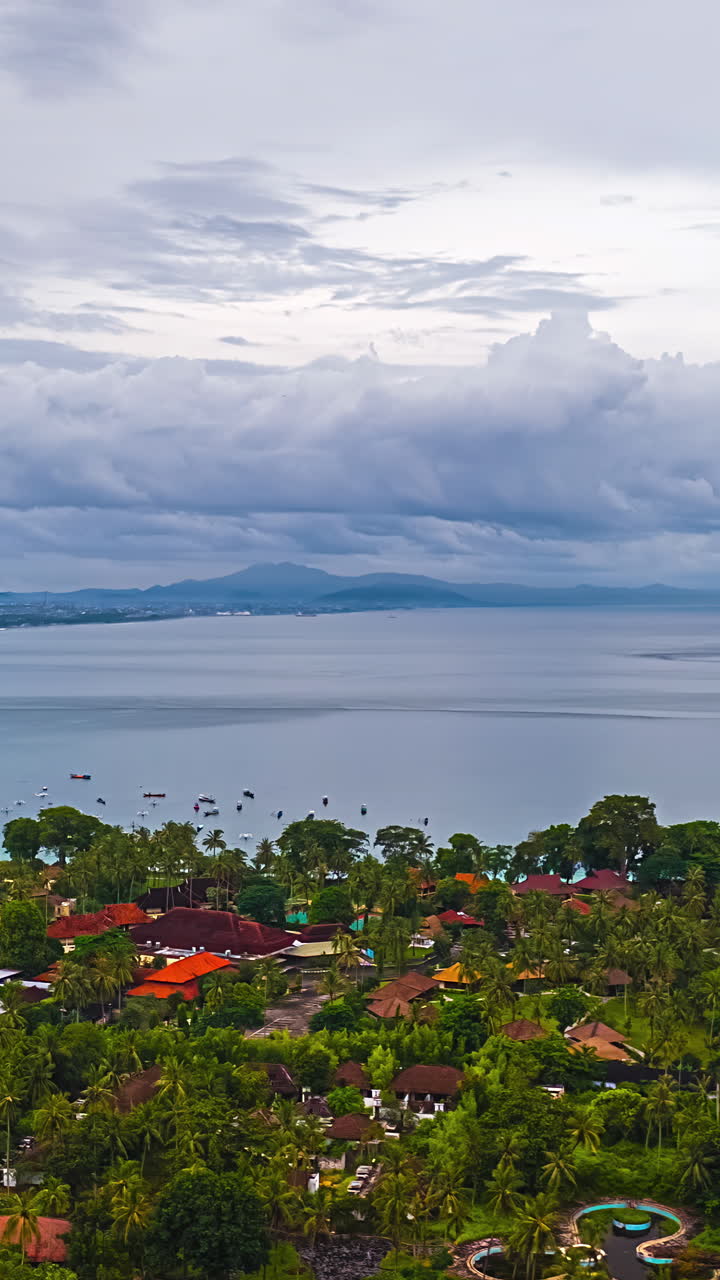 A peaceful coastal village surrounded by lush greenery, captured in a vertical timelapse