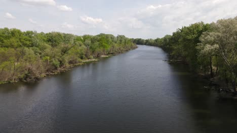 Calm-section-of-Tisza-River-in-Hungary-flowing-through-forest,-wide-aerial-view