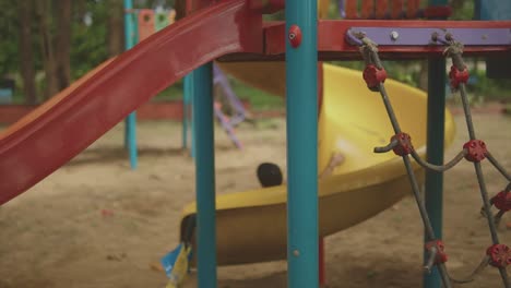 boy enjoying a slide ride in a park, goa, india