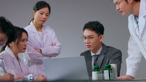 real shot professional male pharmaceutical representative showing prescription medication to doctor in hospital