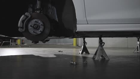 toma de cardán del coche sin rueda elevada con soportes de gato en un taller, concepto de reparación de coches