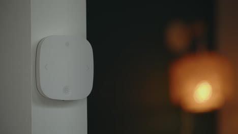 person turns on light by pushing button on smart switch at home