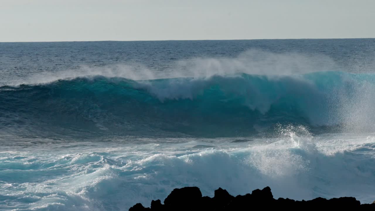 Dramatic ocean waves collide with the volcanic coastline near Timanfaya National Park, located on the island of Lanzarote in the Canary Islands, Spain.