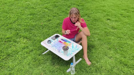 woman beading outdoors on a portable table