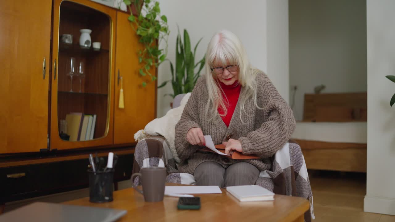 Senior Woman Reading a Letter in Her Living Room