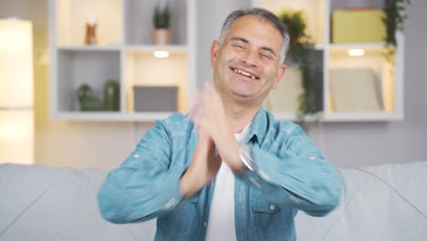 hombre aplaudiendo emocionado a la cámara.