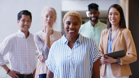 smiling diverse business team standing together in modern office environment