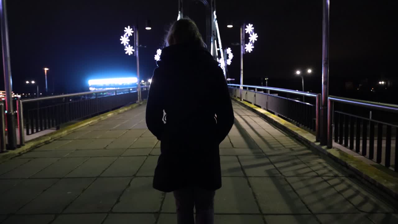 chica caminando por el puente en la noche
