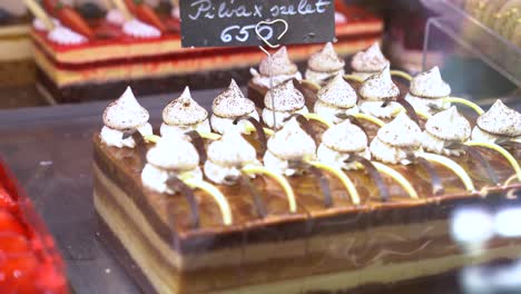 person removes sheet of pilvax cake from bakery display case, close up