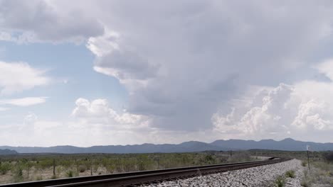 Trains-tracks-surrounded-by-endless-clouds-and-skies,-West-Texas