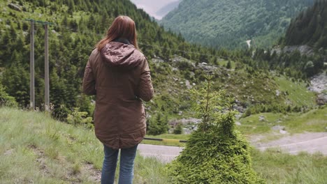 a young woman hiker climbs mountains with photo camera. transfagarasan, carpathian mountains in romania