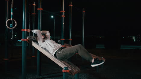 man doing abs workout at night in the park