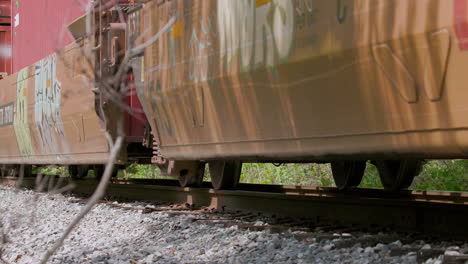 Low-angle-slow-motion-closeup-of-freight-train-cars-passing-by