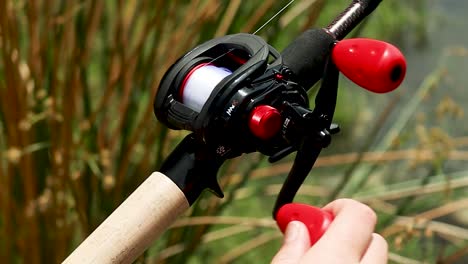 zoomed in shot of hands reeling in a bass reel