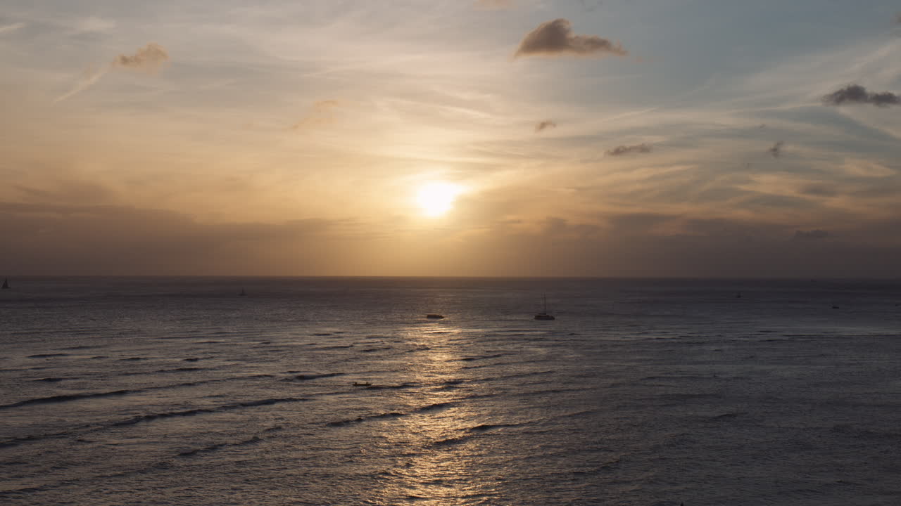 el camino del brillo del sol se esparce sobre las olas del viento de la bahía de waikiki con tenues nubes en el fondo, hawaii