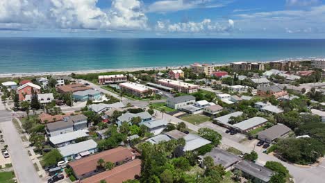 Aerial-flyover-american-neighborhood-near-sandy-beach-and-clear-Atlantic-ocean-in-background