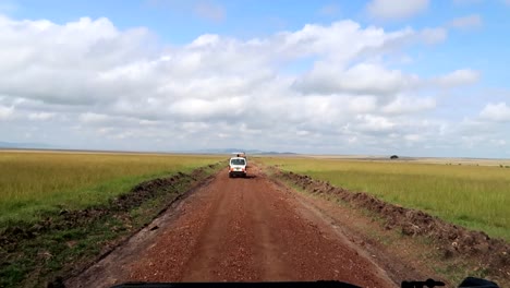 los vehículos van por un camino de tierra en un safari en busca de animales en kenia, áfrica