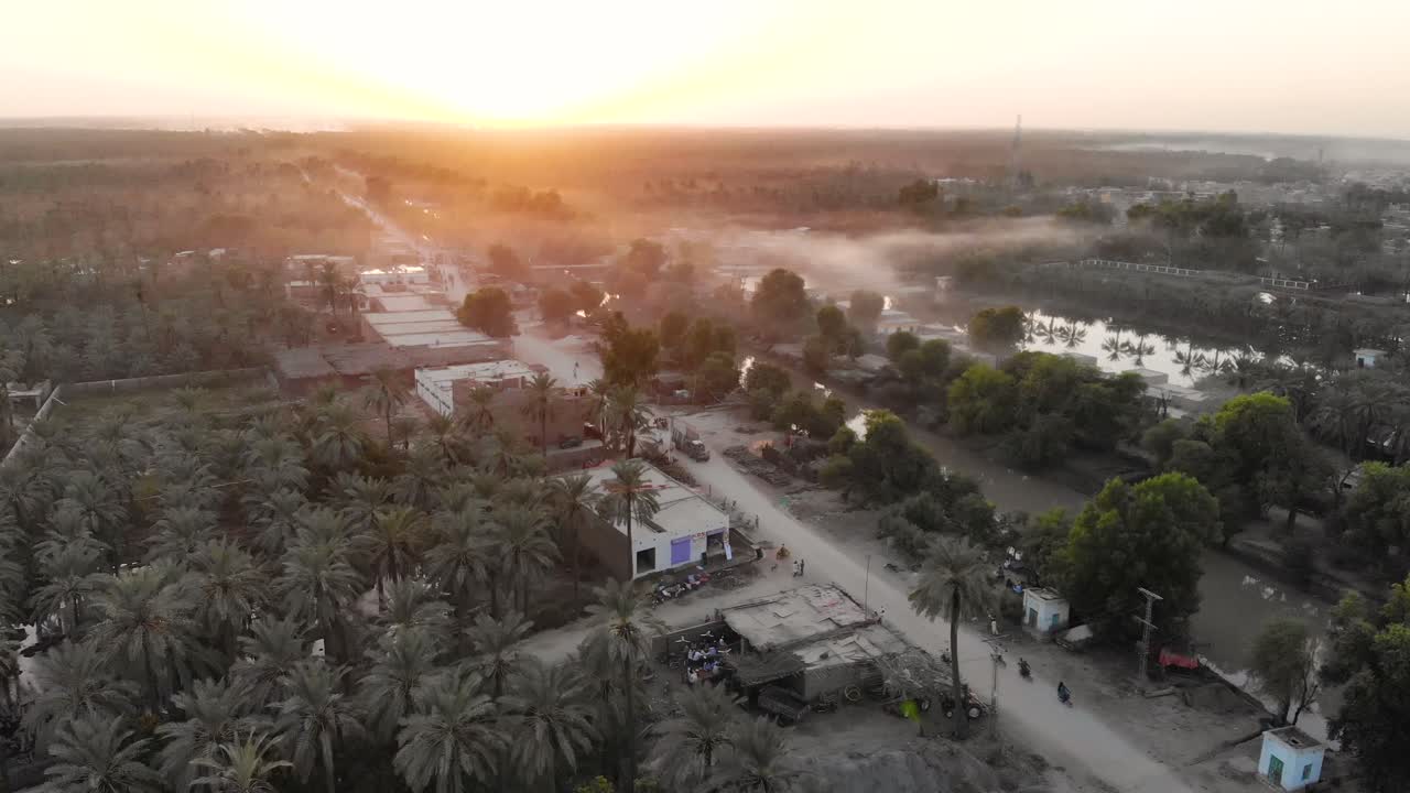 puesta de sol aérea sobre khairpur rural en sindh, paksitan rodeado de palmeras datileras