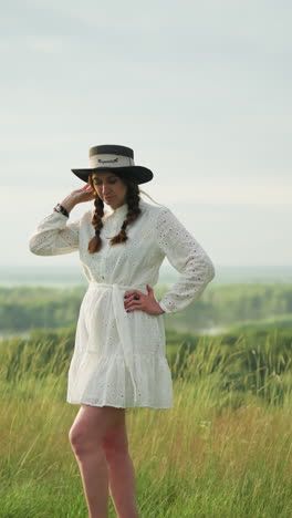 a partially visible artist is capturing the image of a poised woman in a white dress and black hat on canvas. the scene is set in a peaceful grassy landscape, blending creativity with nature's