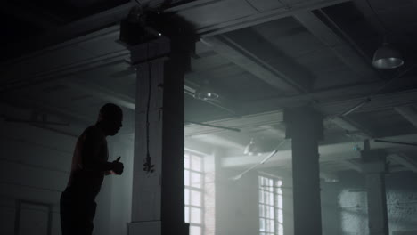 entrenamiento de kickboxer en un edificio de ático. atleta preparándose para una competencia de pelea