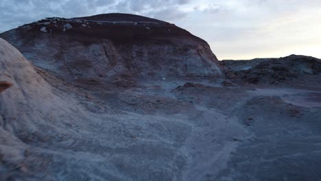 quick aerial pullback through alien-like rock formation in bentonite hills hanksville utah during sunset