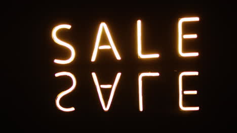 neon lights spell out ''sale'' against a dark background