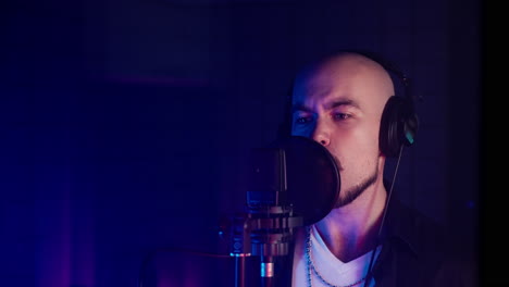 man singing into a microphone in a recording studio