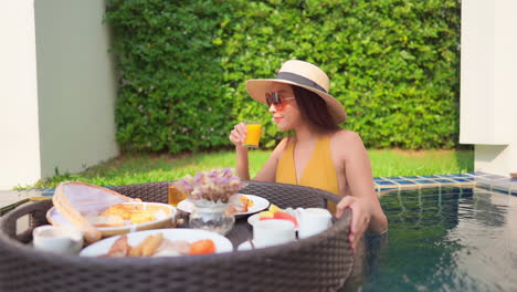 breakfast in floating plate and sexy exotic woman in swimming pool, luxury vacation concept, slow motion full frame