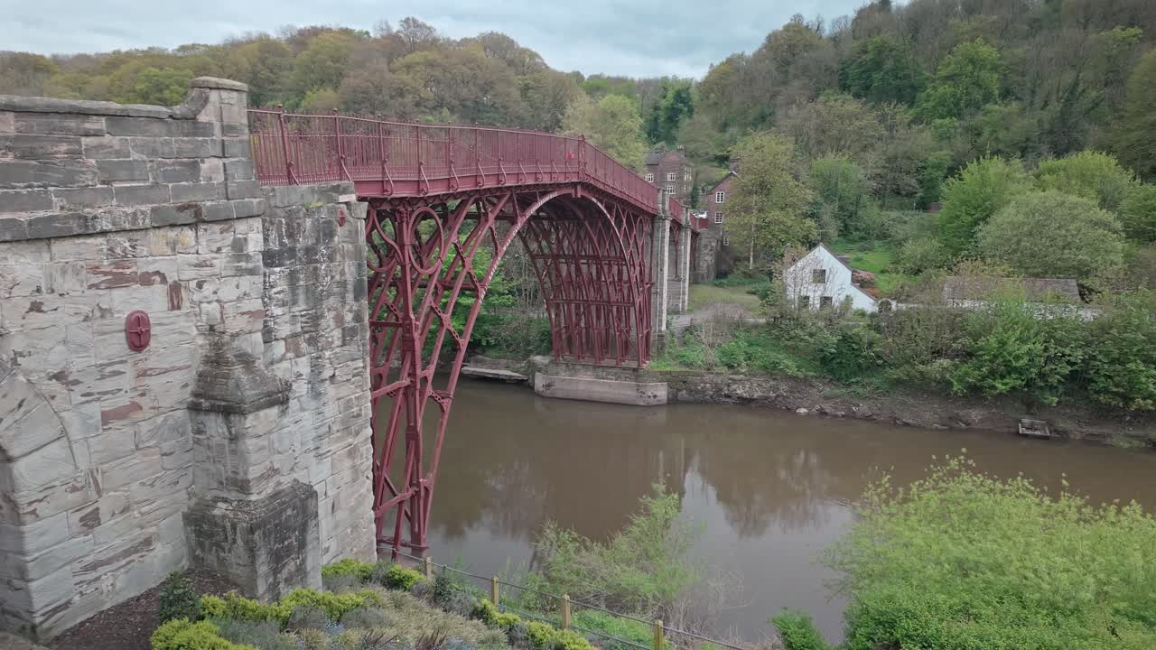 River Severn flows under red painted cast Iron toll bridge, Ironbridge