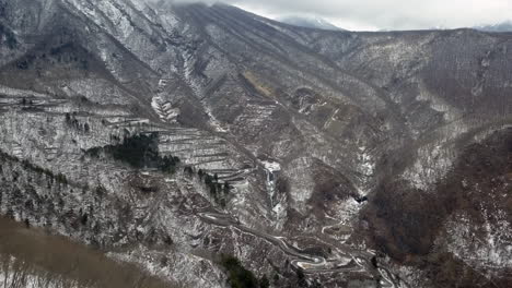 aerial dolly of snow covered slopes along the irohazaka winding road, nikko, tochigi, japan