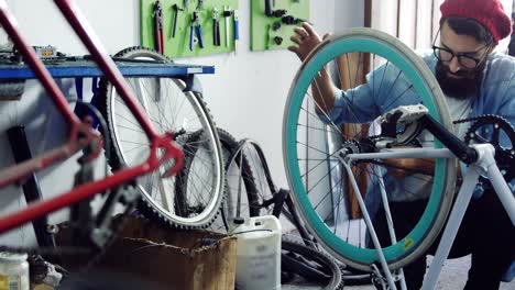 mechanic repairing bicycle in workshop