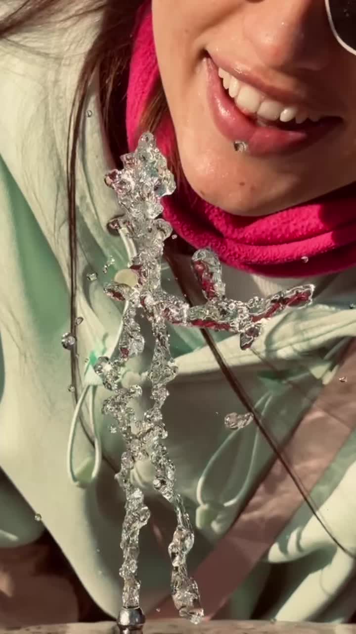 Primo piano di una persona che beve acqua rinfrescante da una fontana