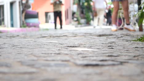personas caminando por una calle de adoquines
