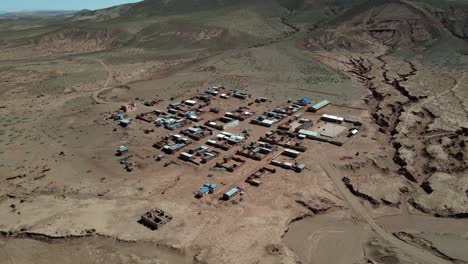 close aerial of village houses in bolivian highlands shows simple rooftops and dry terrain