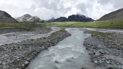 Drone-Volando-Sobre-Una-Corriente-De-Agua-Que-Fluye-A-Través-De-Los-Alpes,-Italia