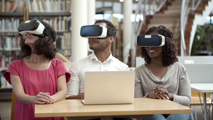 Lächelnde Nutzer mit VR-Headsets sitzen in der Bibliothek
