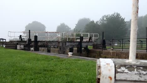 industrial british canal lock gates towpath on english misty morning parallax right